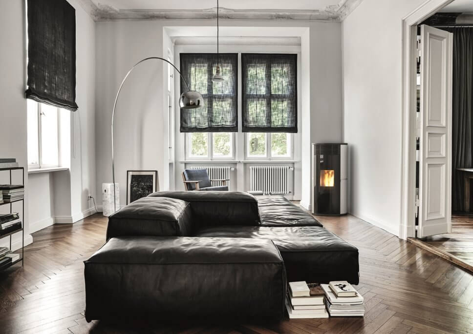 Modern eingerichtetes Wohnzimmer mit Kaminofen im Mittelpunkt