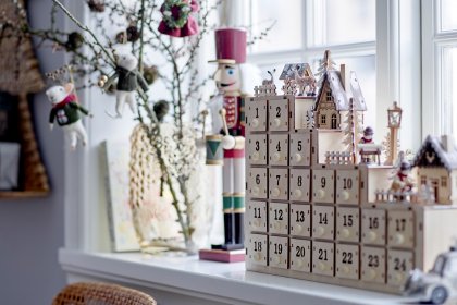 Adventskalender aus Holz in weihnachtlich geschmücktem Zimmer