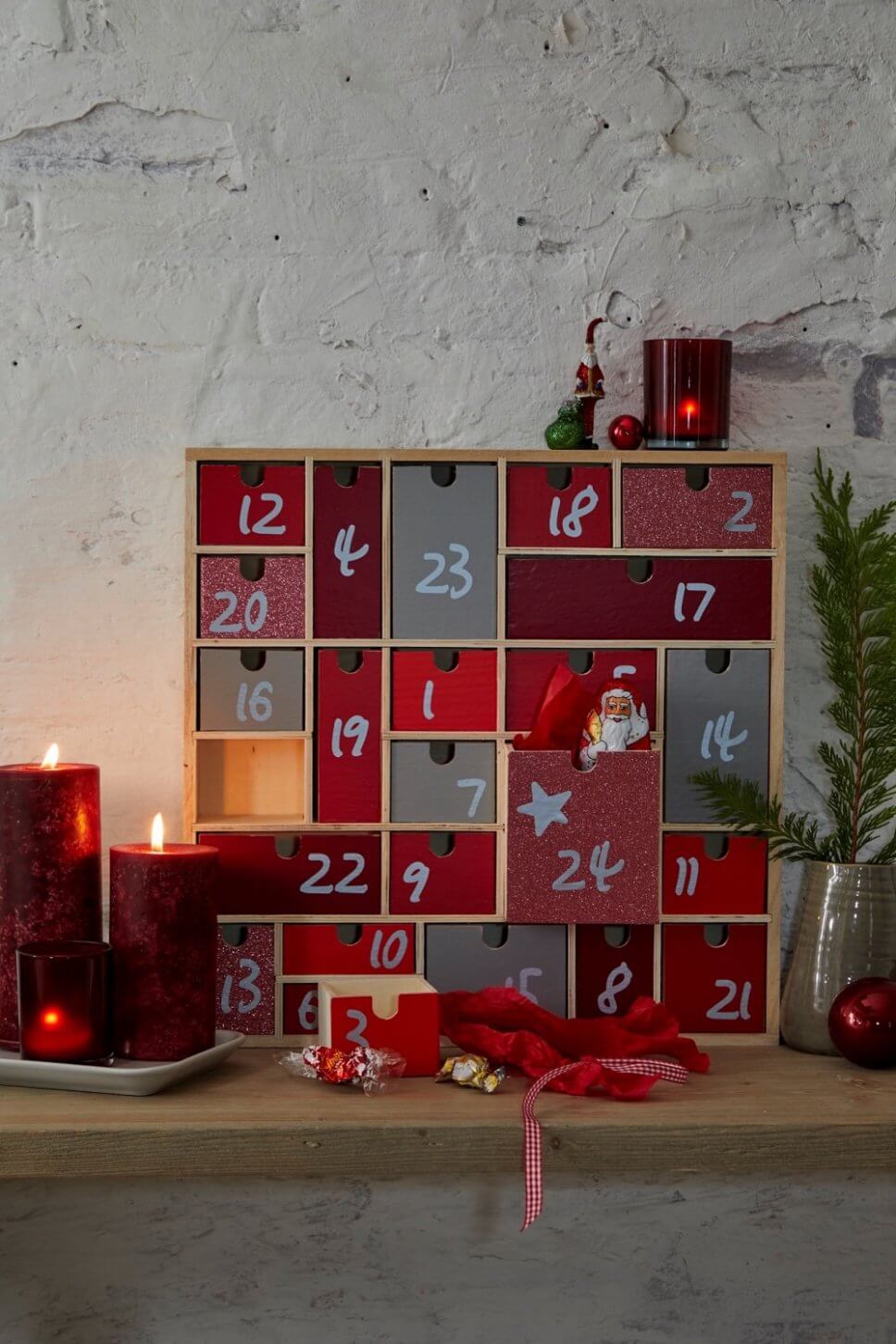 Adventskalender aus Holz in weihnachtlich geschmücktem Zimmer
