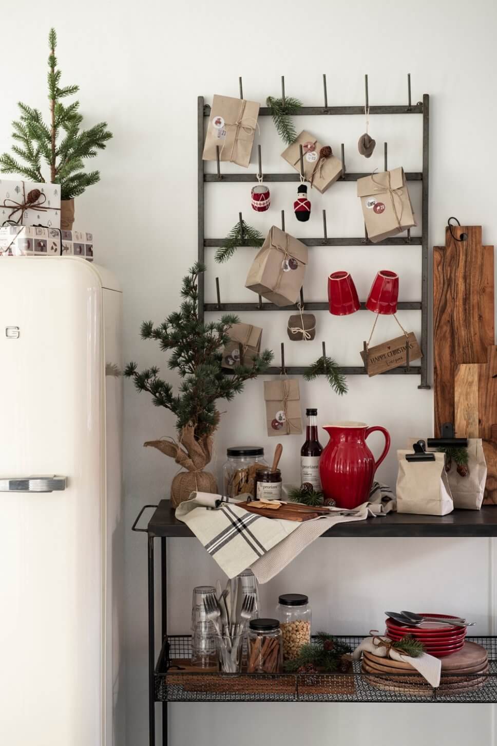 Weihnachtlich geschmückter Tassenregal aus Metall mit kleinen Geschenken behängt