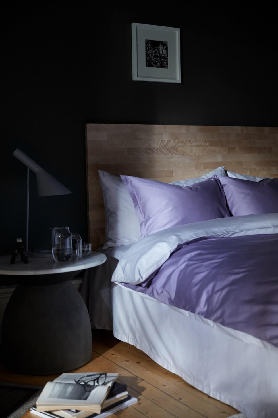 Modern eingerichtetes Schlafzimmer mit lila Bettwäsche