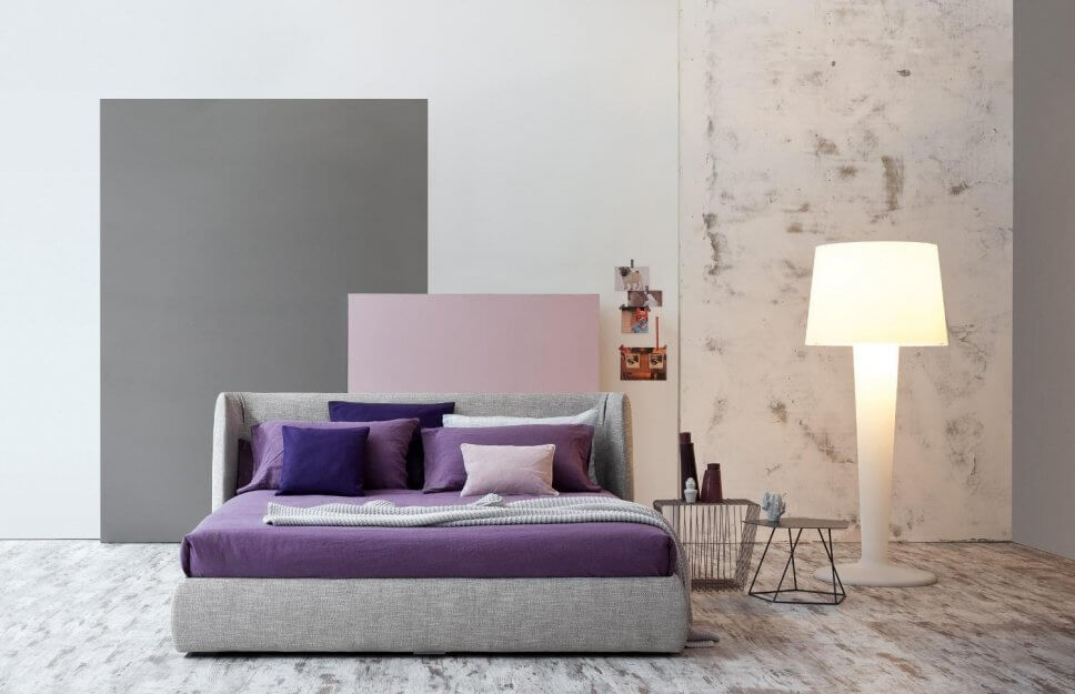 Modern eingerichtetes Schlafzimmer mit lila Bettwäsche