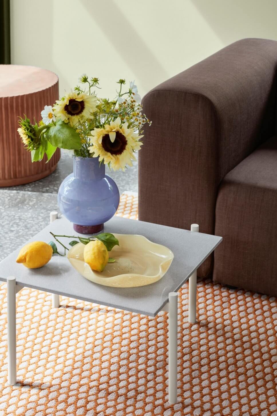 Modern eingerichtetes Wohnzimmer mit braunem Sofa und lila Vase auf Coffeetable