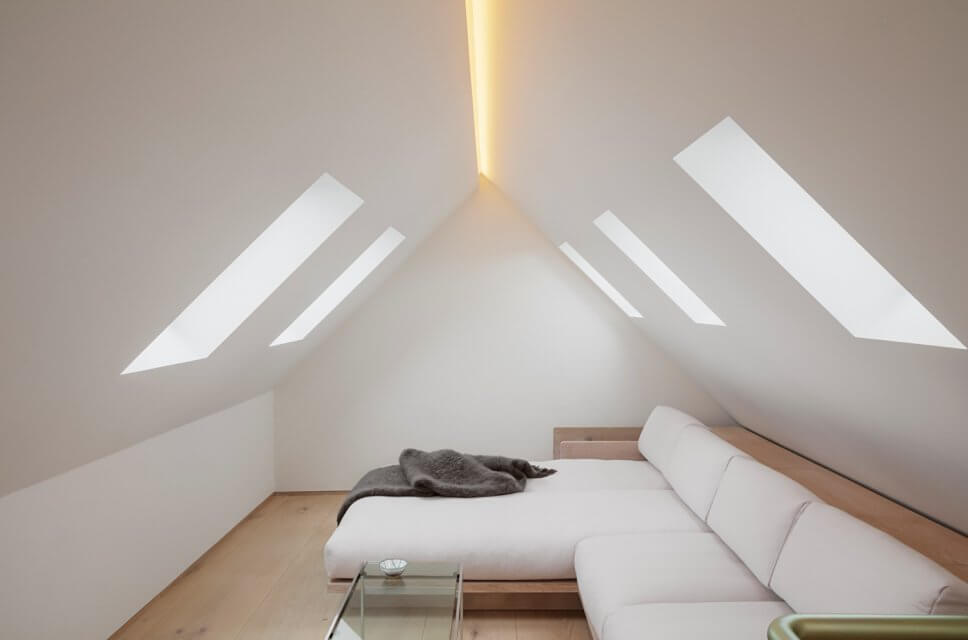 Skandinavisch minimalistisch eingerichtetes Wohnzimmer in Dachgeschosswohnung