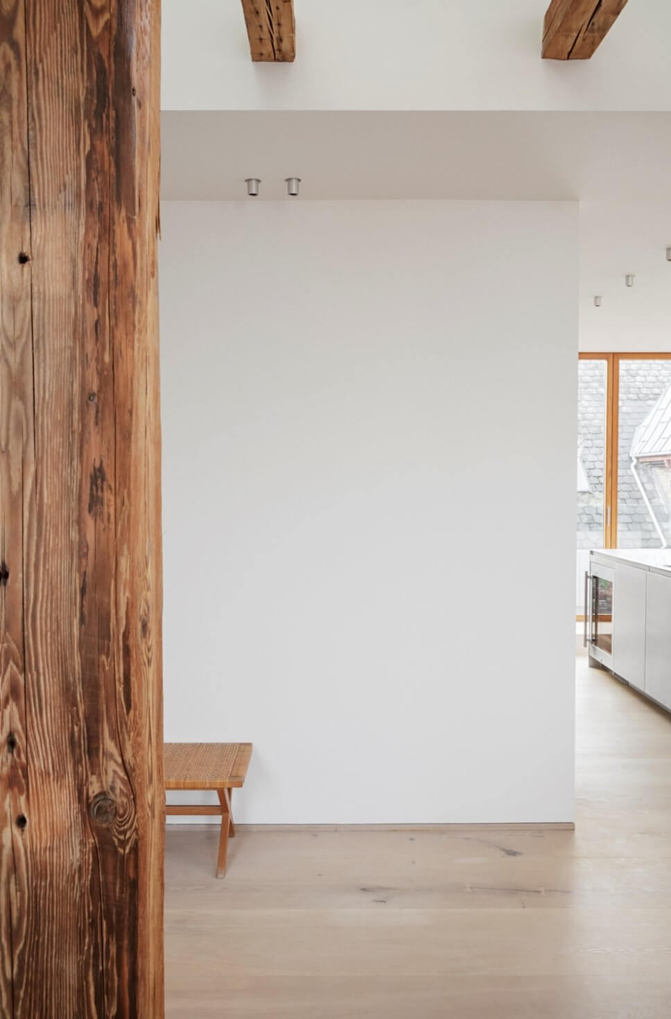 Skandinavisch minimalistisch eingerichteter offener Wohnraum mit Küche in Dachgeschosswohnung