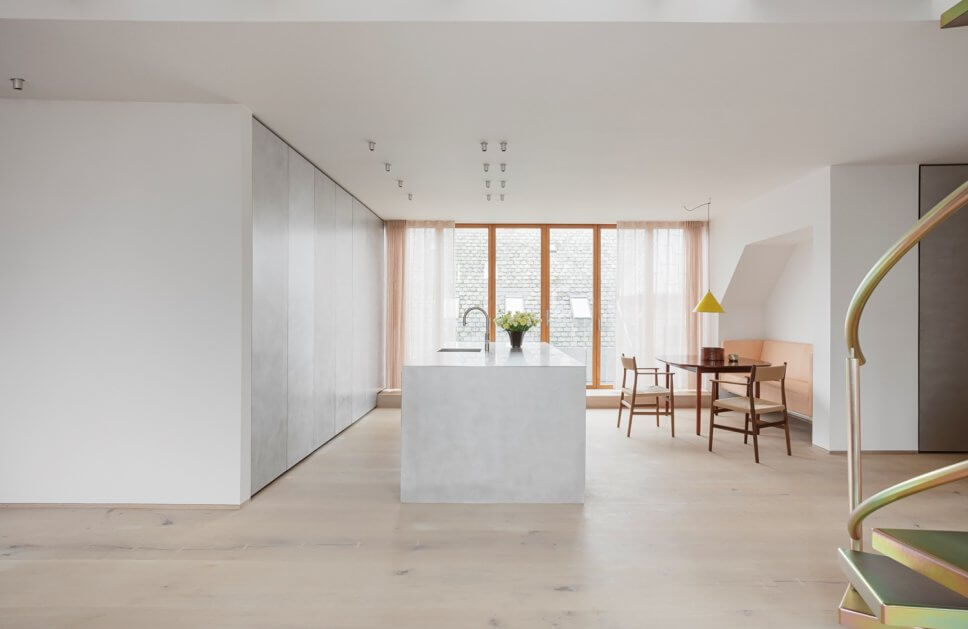 Skandinavisch minimalistisch eingerichteter offener Wohnraum mit Küche in Dachgeschosswohnung