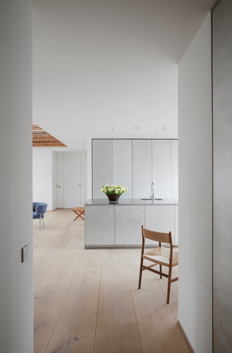 Skandinavisch minimalistisch eingerichteter offener Wohnraum mit Küche in Dachgeschosswohnung