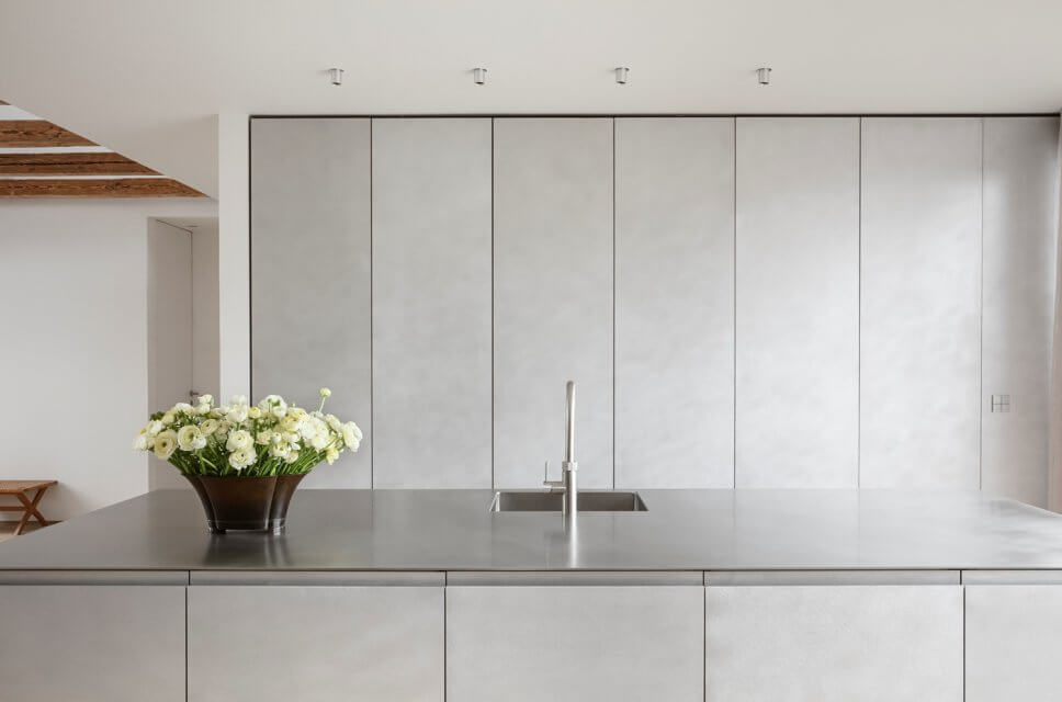 Skandinavisch minimalistisch eingerichteter offener Wohnraum mit Küche in Dachgeschosswohnung