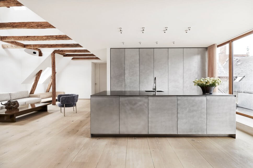 Skandinavisch minimalistisch eingerichteter offener Wohnraum mit Küche in Dachgeschosswohnung
