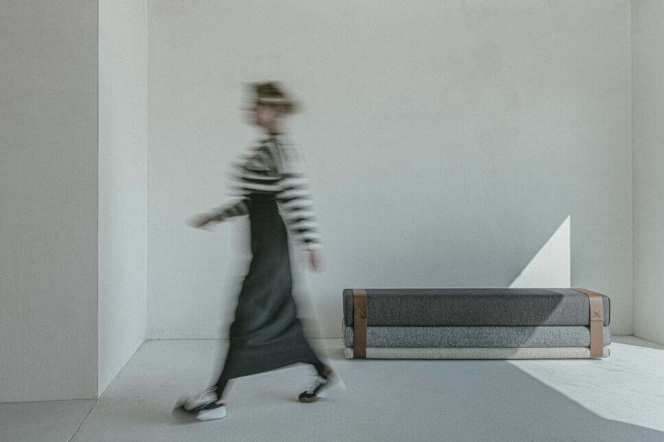 Frau geht neben einer Polsterbank