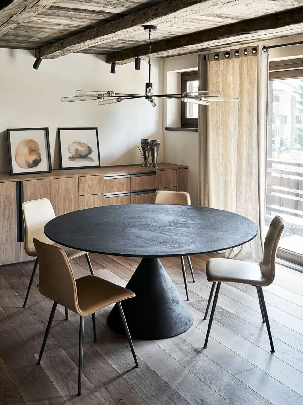 Minimalistisch eingerichteter offener Wohnraum mit Esstisch und Stühlen im modernen Chalet-Stil