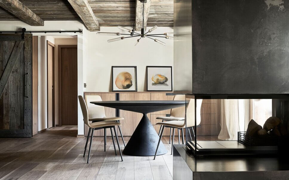 Minimalistisch eingerichteter offener Wohnraum mit Esstisch und Stühlen im modernen Chalet-Stil