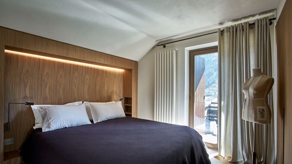 Minimalistisch eingerichtetes Schlafzimmer mit Polsterbett und Einbauschrank