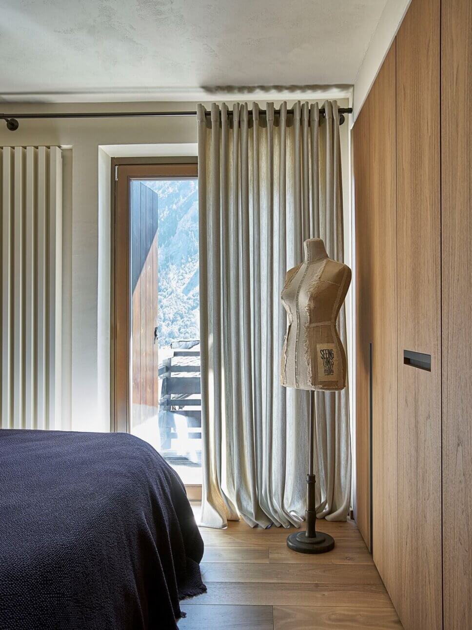 Minimalistisch eingerichtetes Schlafzimmer mit Polsterbett und Einbauschrank