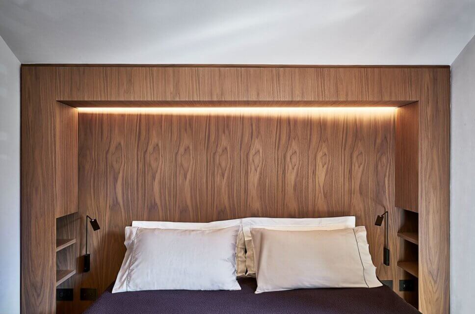 Minimalistisch eingerichtetes Schlafzimmer mit Polsterbett und Einbauschrank