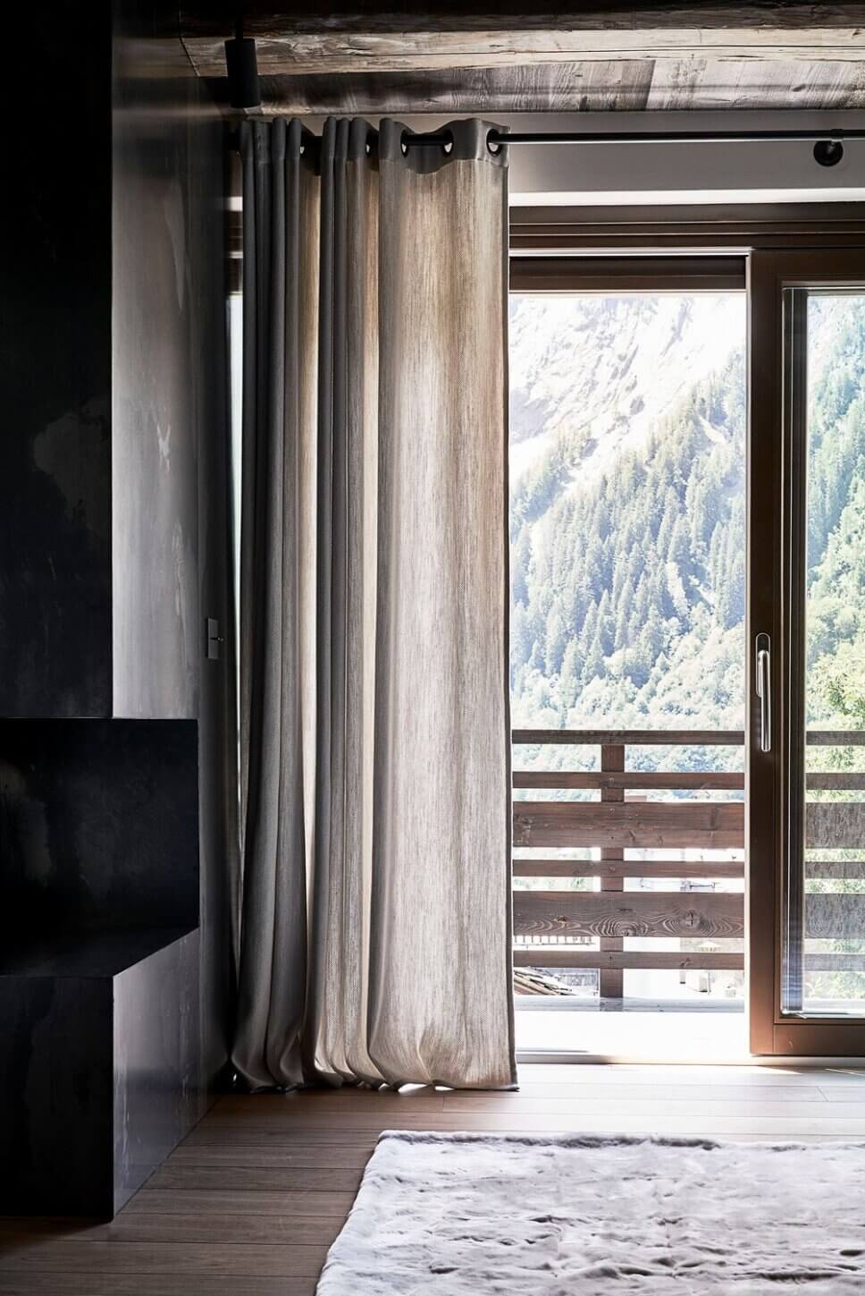 Minimalistisch eingerichteter offener Wohnraum mit Kamin im modernen Chalet-Stil