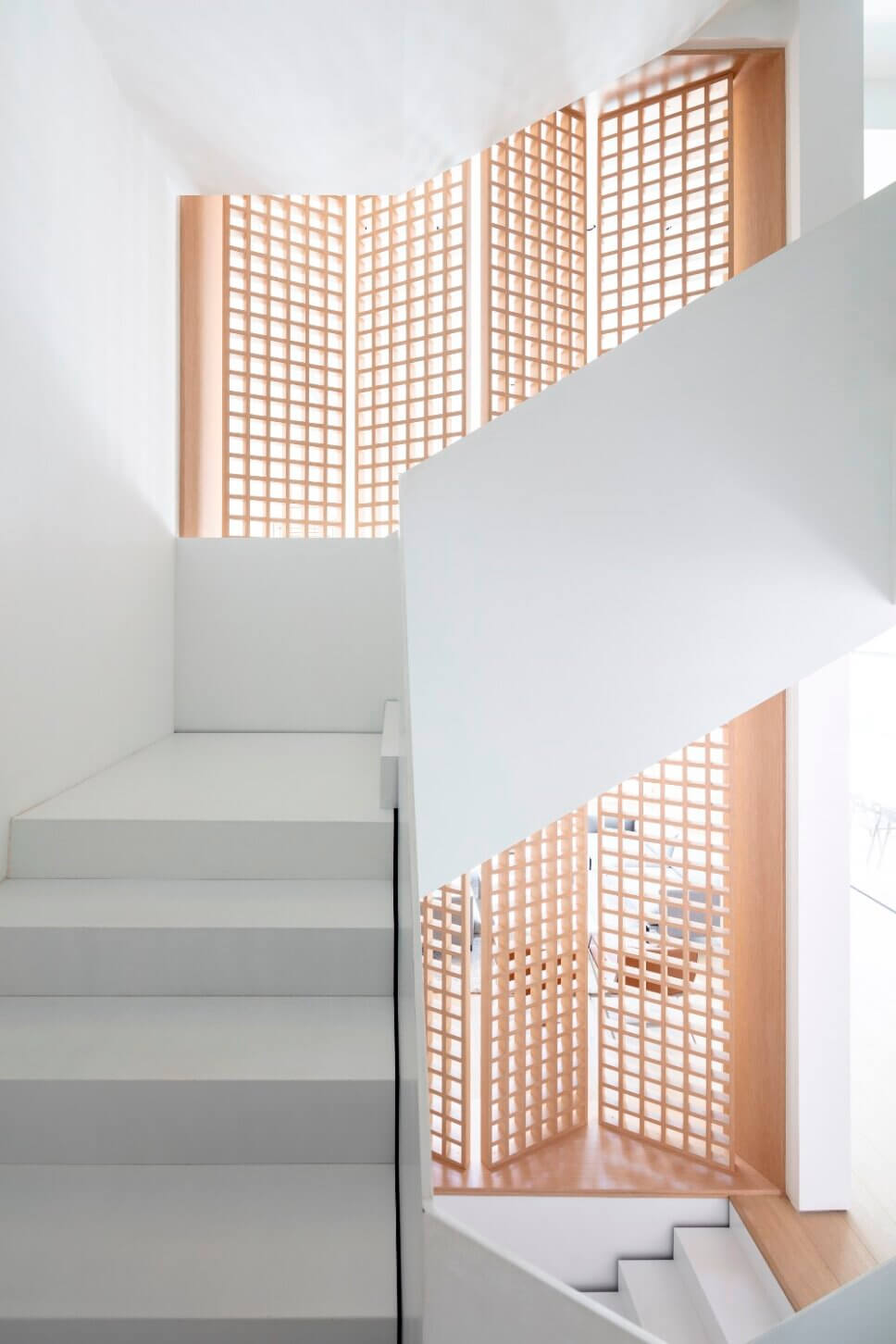 Treppe in minimalistisch eingerichtetem offenen Wohnraum