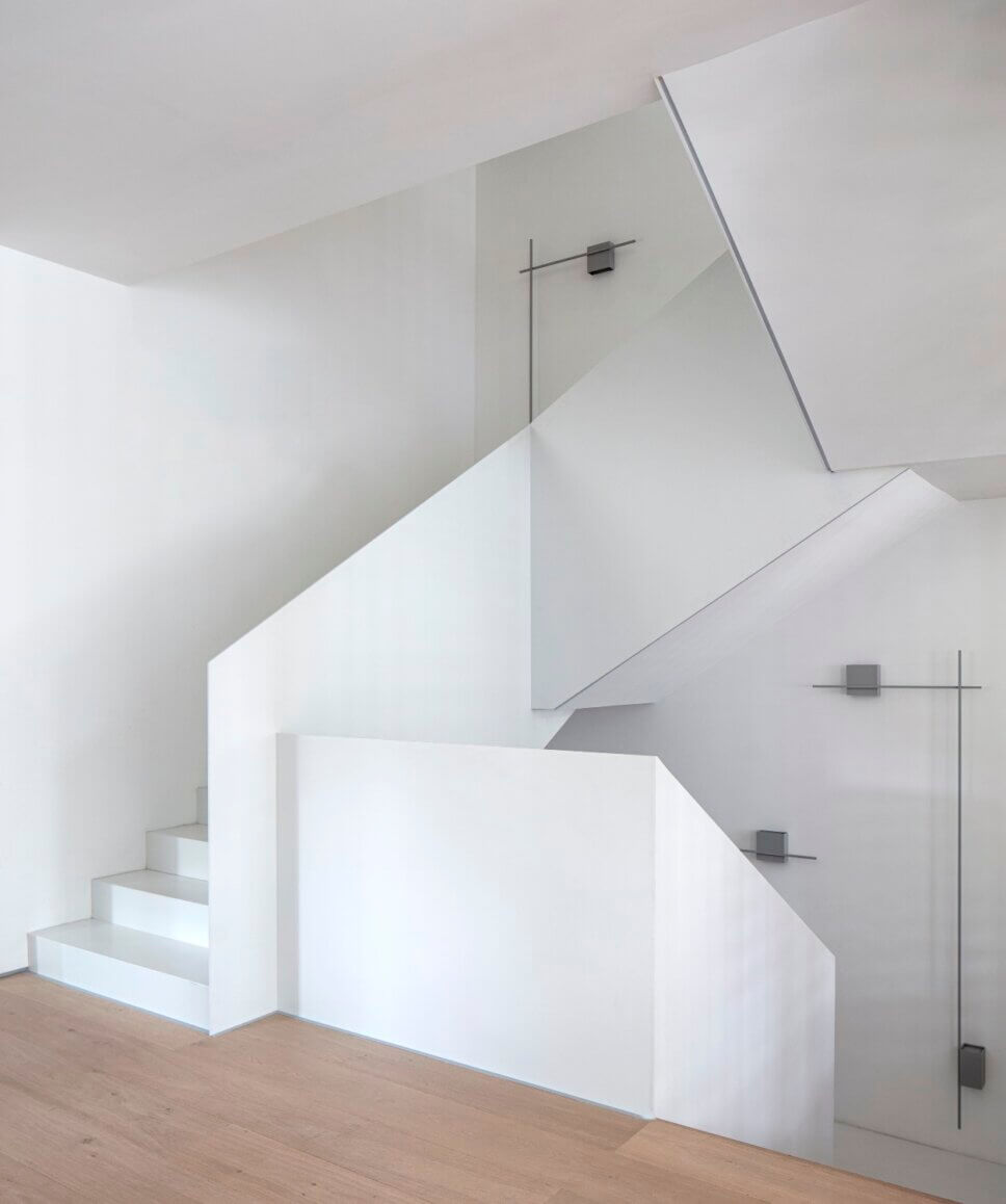 Treppe in minimalistisch eingerichtetem offenen Wohnraum