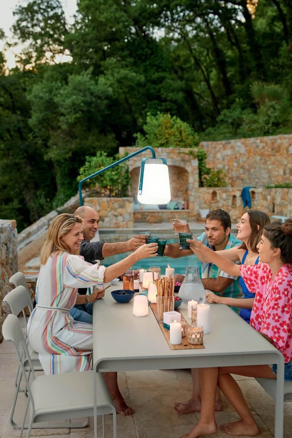 Menschen prosten sich am Gartentisch zu