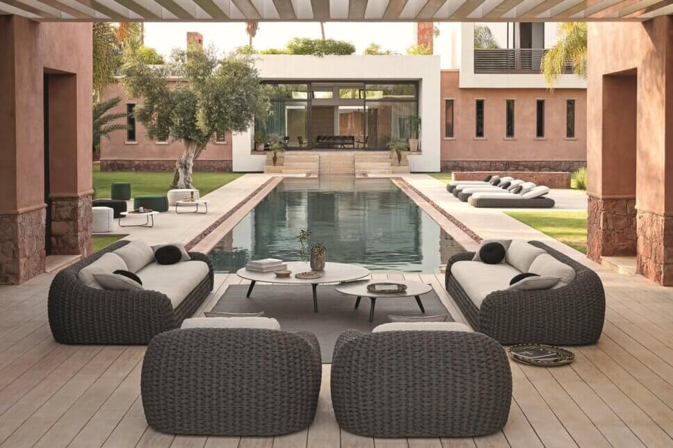 Modernes Gartensofa auf Terrasse neben Pool