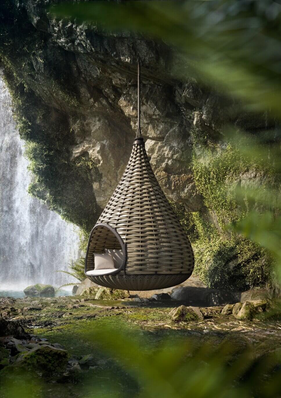Moderner Hängessel aus Geflecht hängt neben wasserfall