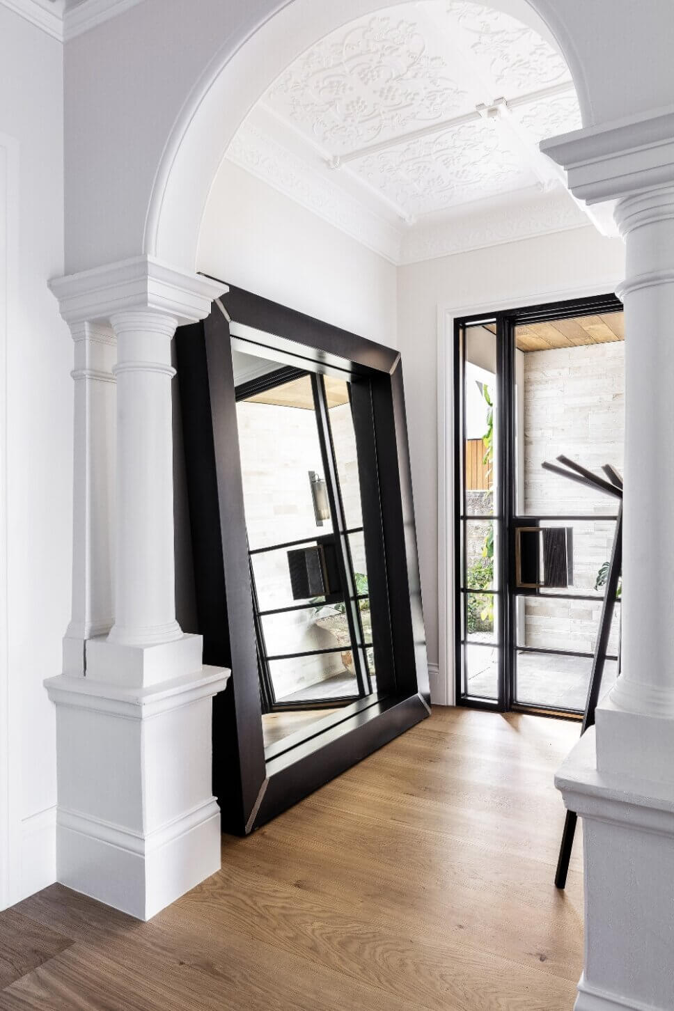 Hauseingang einer Villa mit großem an der Wand angelehnten Spiegel