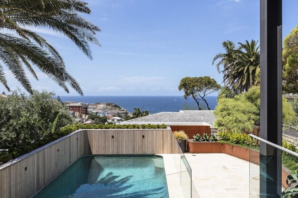 Üppig bepflanzter Garten mit Pool und Blick auf Meer