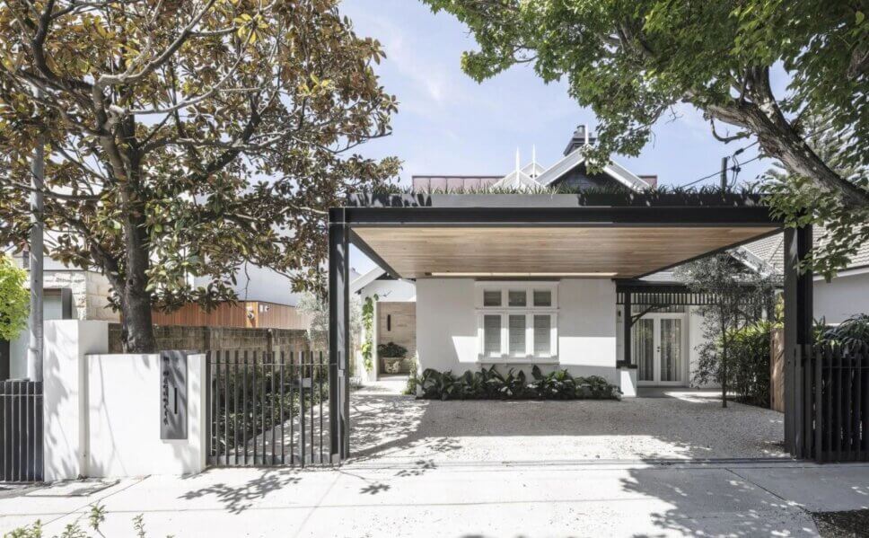 Eingang einer Villa mit üppiger Bepflanzung im Vorgarten