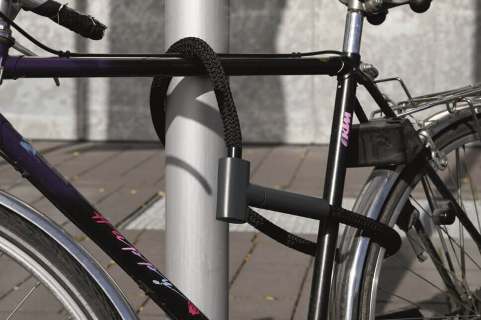 Mit einem Schloss mit langem Schlauch angeschlossenes Fahrrad