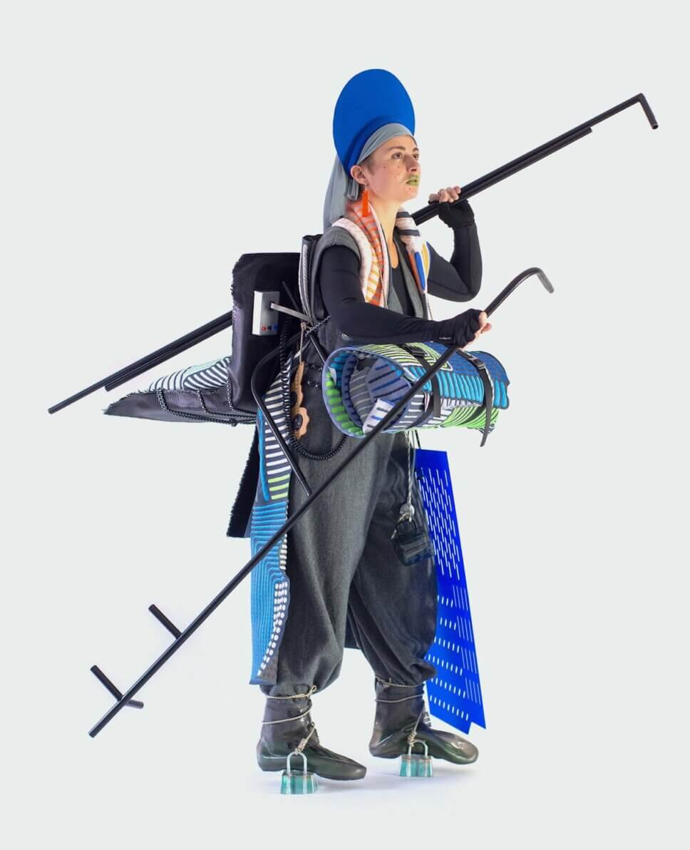 Frau mit Jaquarddecken als Umhang und aufgerollt als Decke