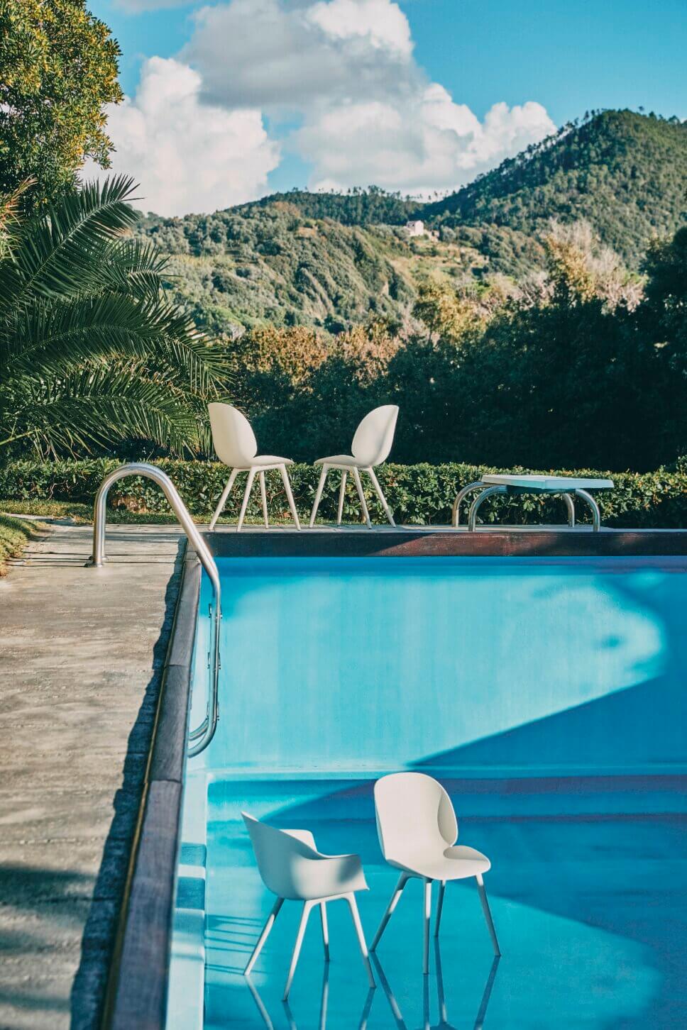 Moderne Gartenstühle am und im Swimming Pool