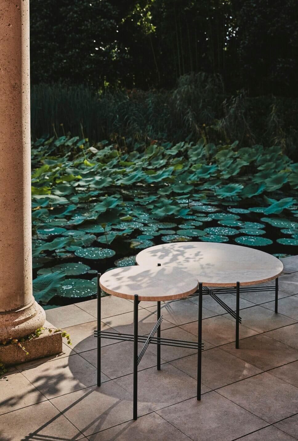 Coffetable stehen auf der Terrasse vor Gartenteich