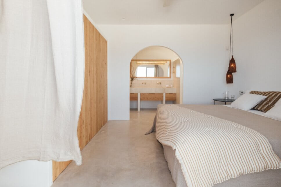 Bett in Schlafzimmer mit Bad en suite in moderner spanischer Finca