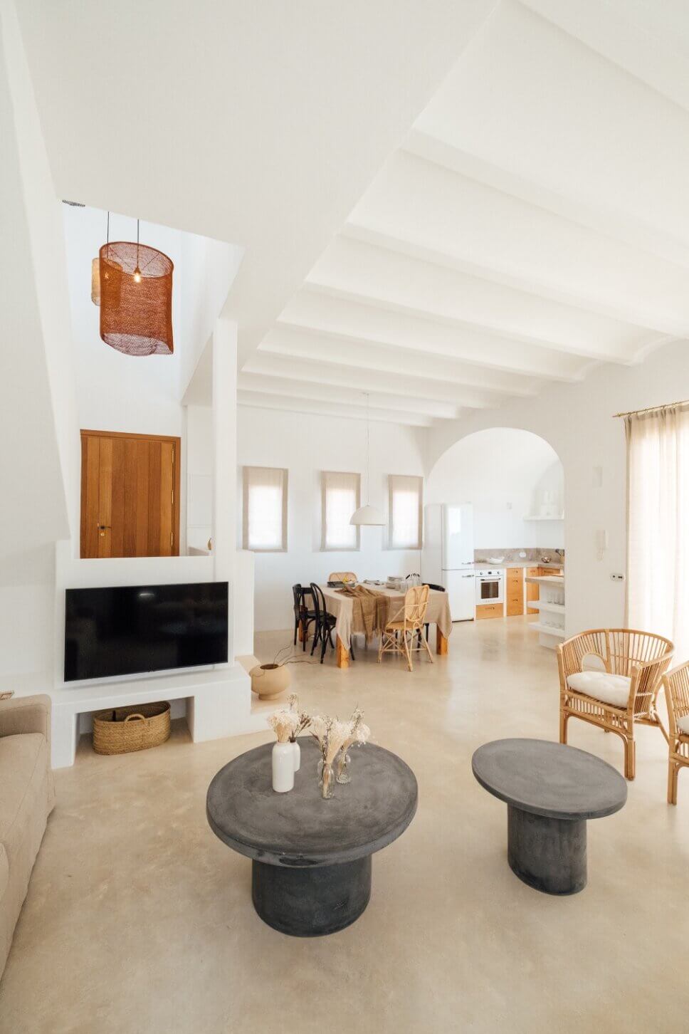 Eingang in moderner spanischer Finca mit Blick in offene Küche und Tonvase im Vordergrund