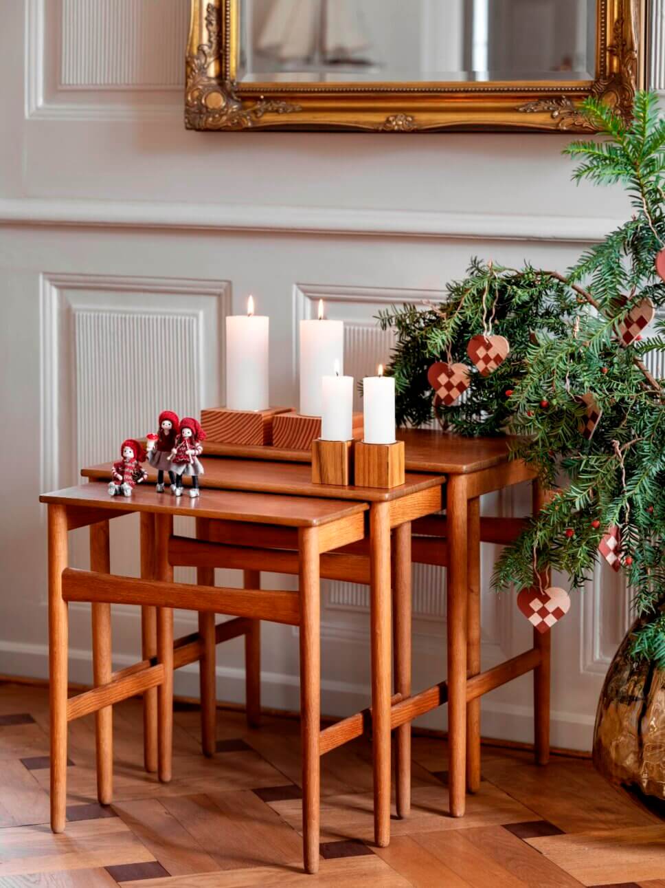 Drei Weihnachtselfen aus Filz mit Strickmützen stehen auf Beistelltisch