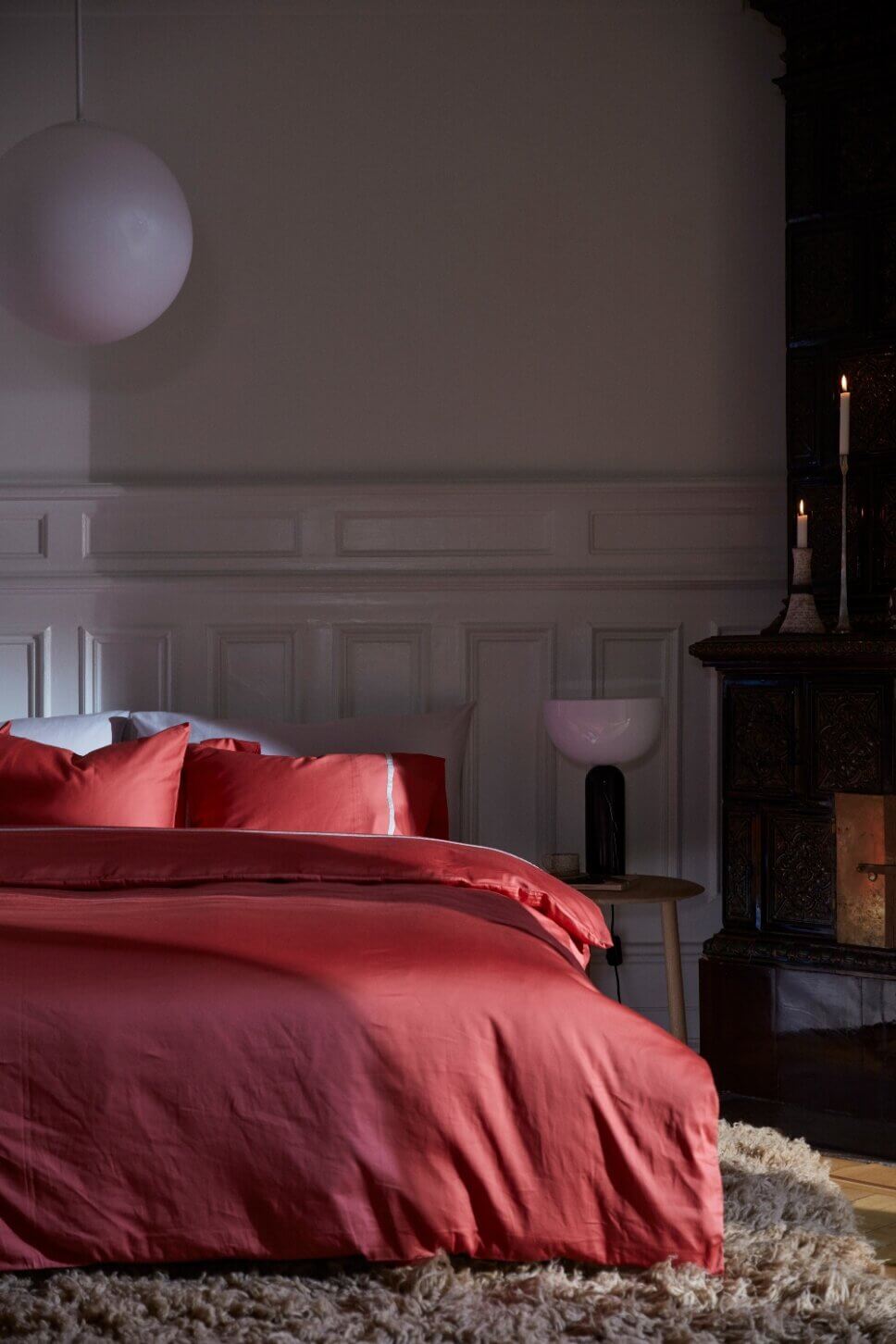 Rote Bettwäsche auf Bett in modern eingerichtetem Schlafzimmer