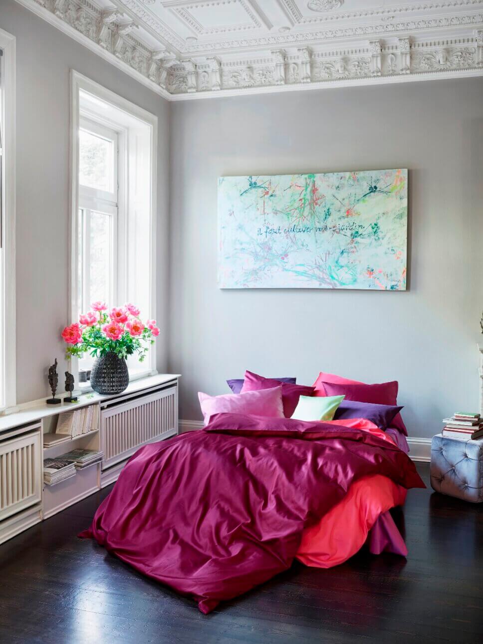 Rote Bettwäsche auf Bett in modern eingerichtetem Schlafzimmer