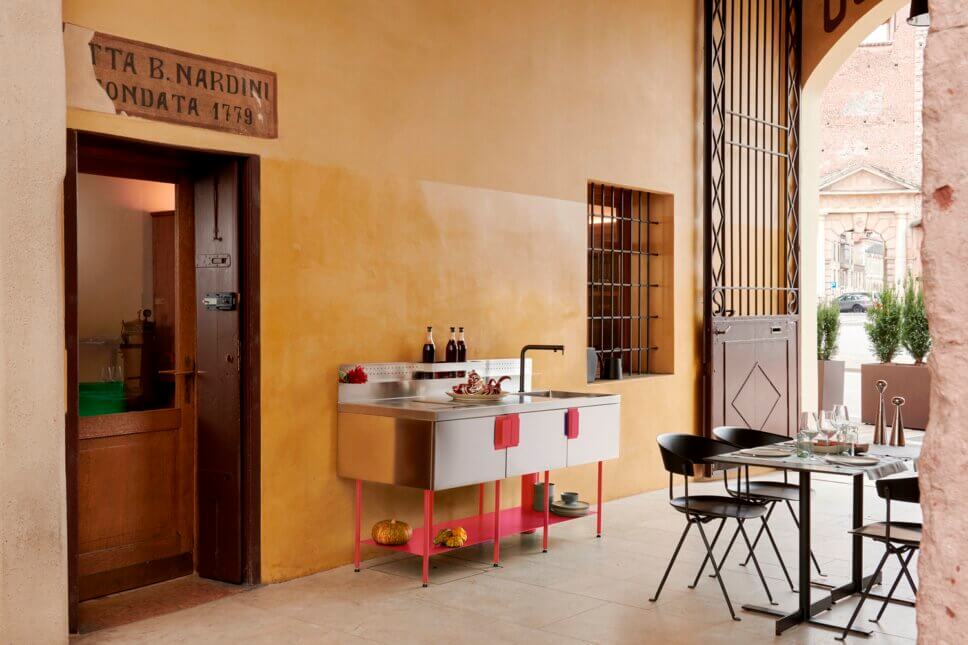 Outoorküche aus Metall mit roten Details in einem Innenhof