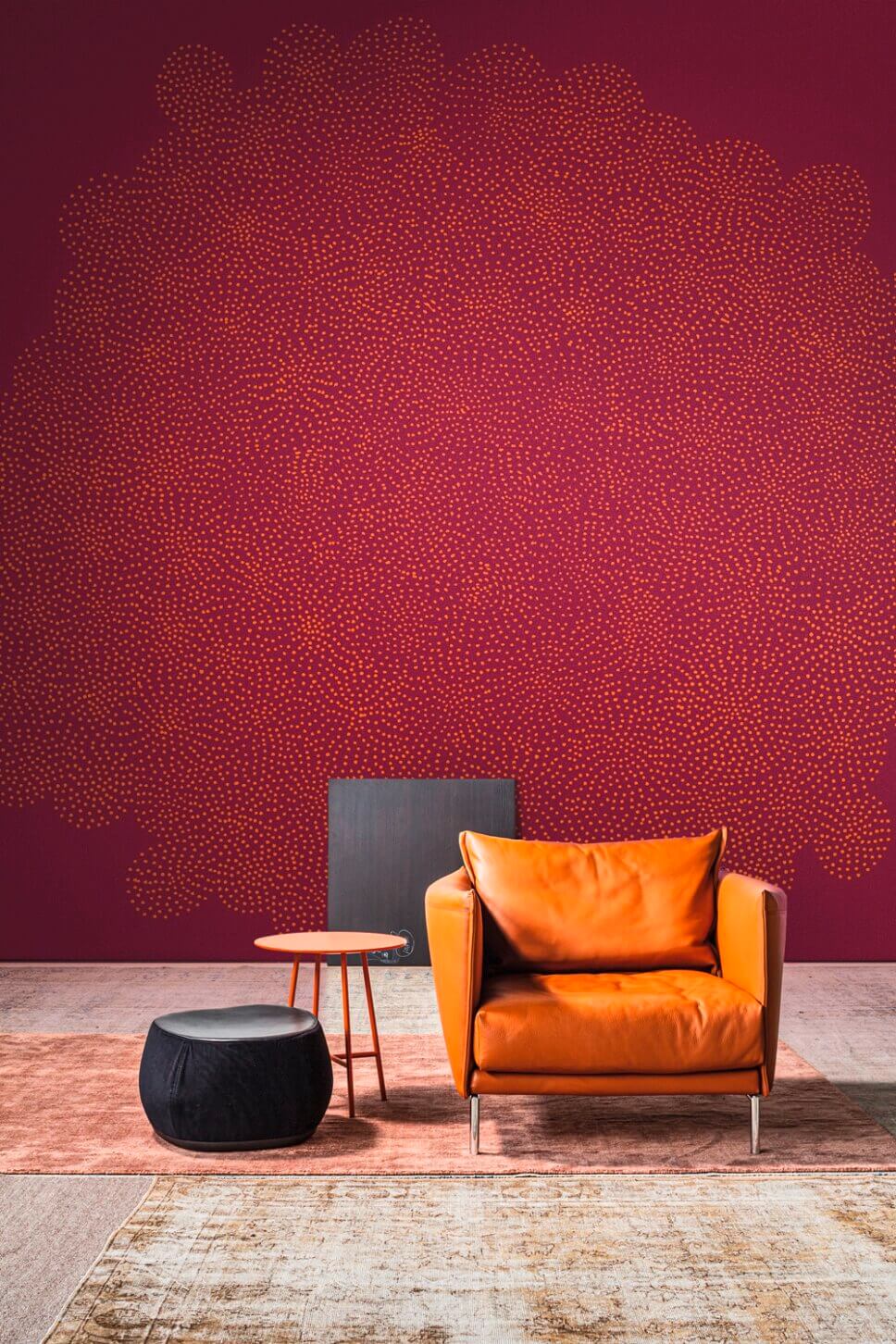 Sessel steht vor gemusterter Tapete in Magenta