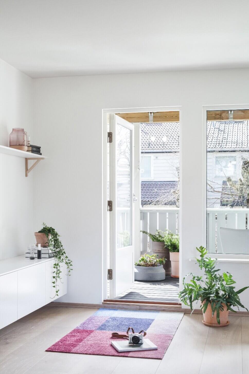 Rot gemusterter Teppich in modernem Wohnzimmer vor Balkon