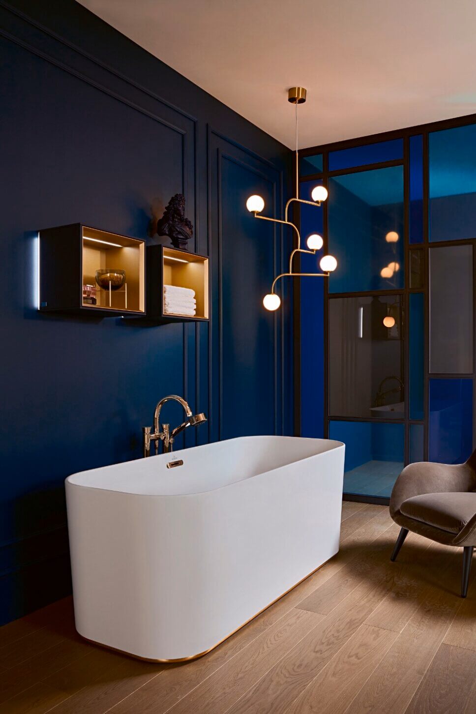 Modern eingerichtetes Badezimmer mit freistehender Badewanne und goldenem Wasserhahn