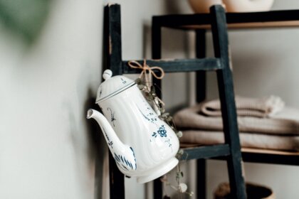 Klassische Kaffeekanne hängt an Holzleiter