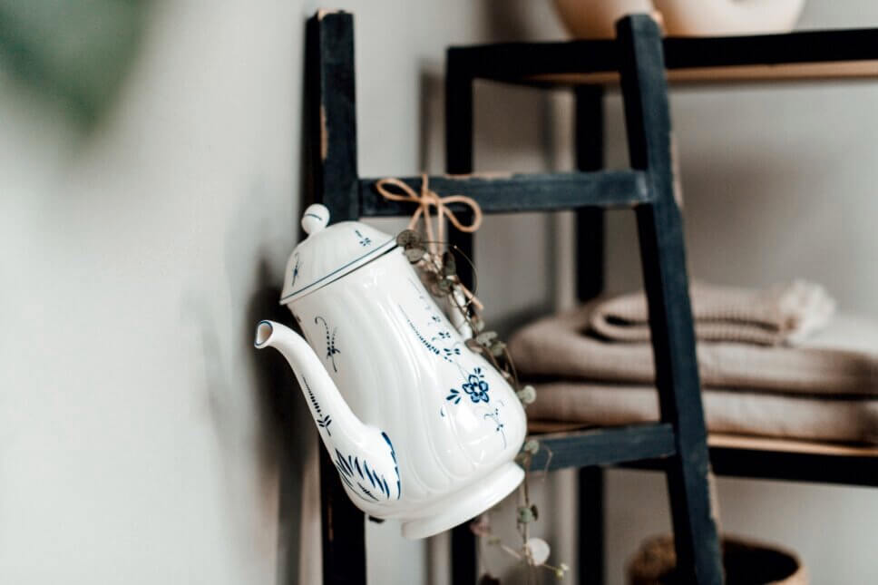 Klassische Kaffeekanne hängt an Holzleiter