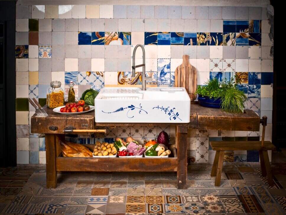 Mit blauer Malerei verzierter Spülstein auf alter Werkbank in Altbauküche