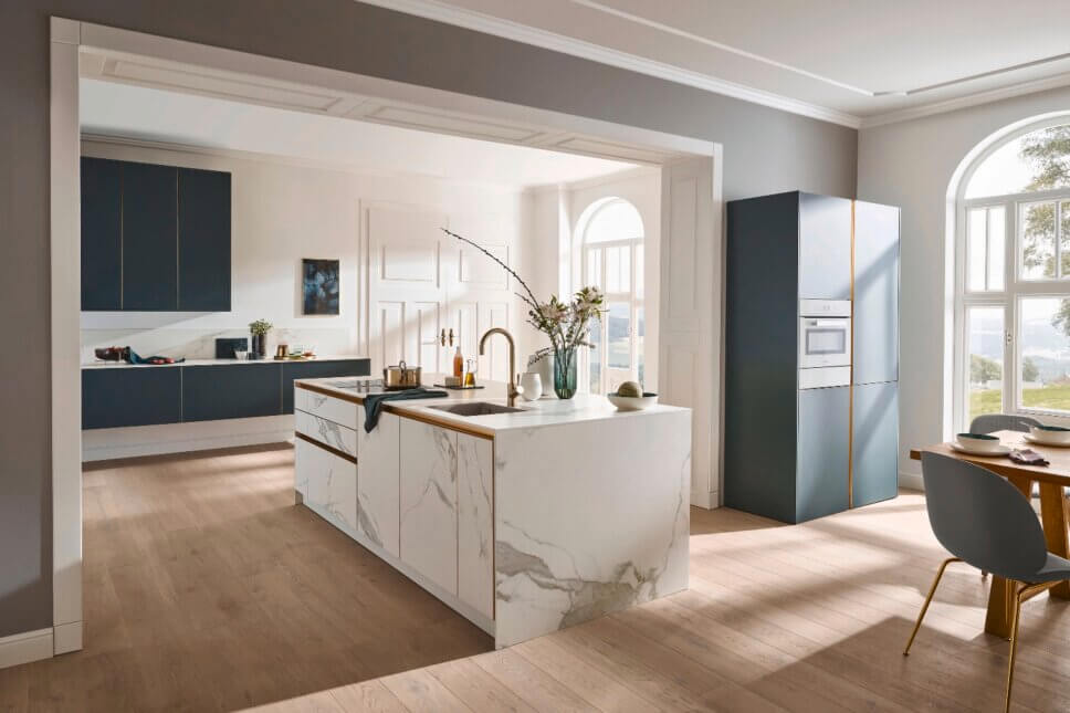 Modern eingerichtete Küche mit eingelassenem Keramikspülbecken und goldenem Wasserhahn