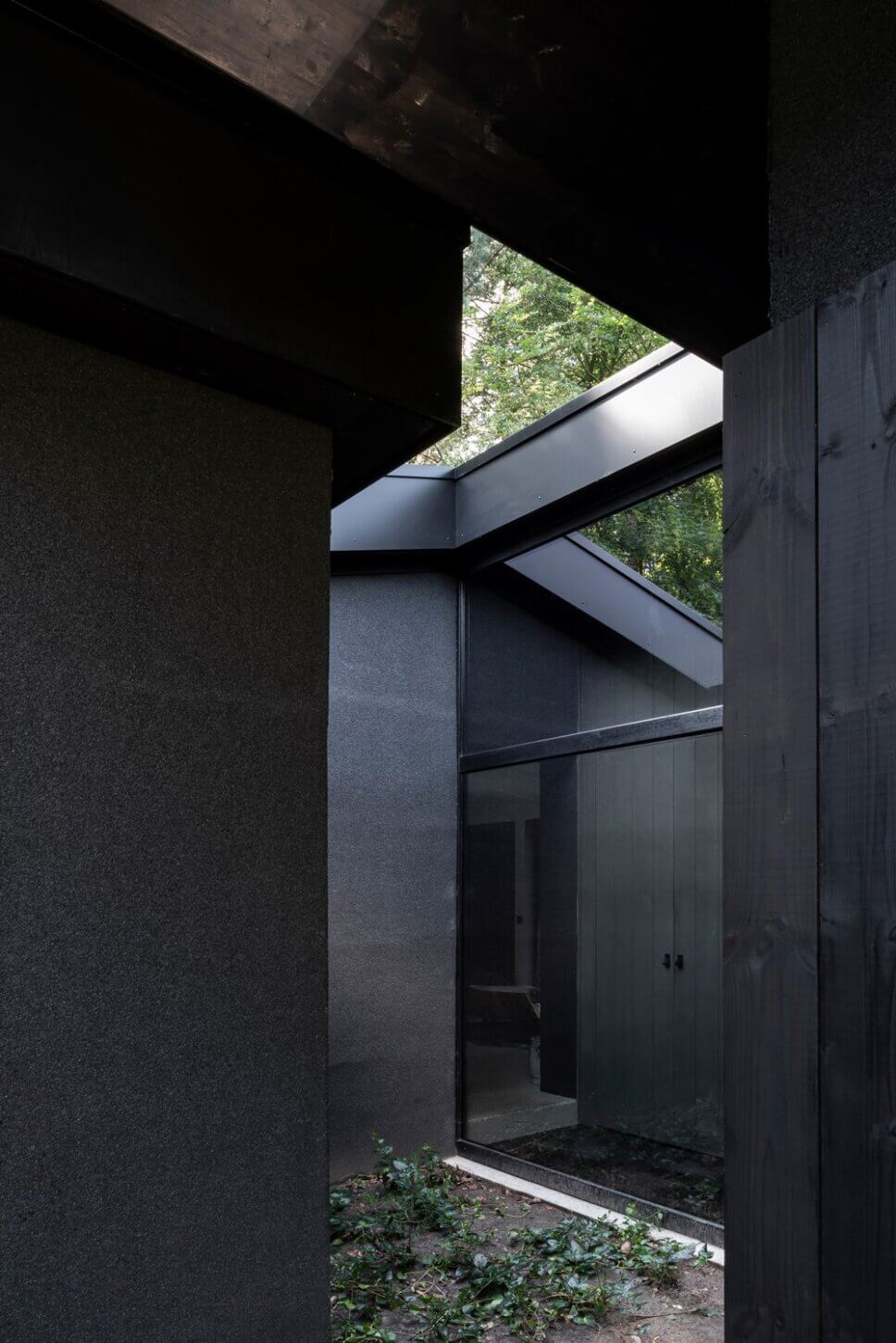 Mit schwarzem Holz verkleideter moderner Bungalow