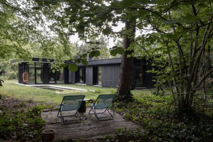 Mit schwarzem Holz verkleideter moderner Bungalow mit Pool im Garten