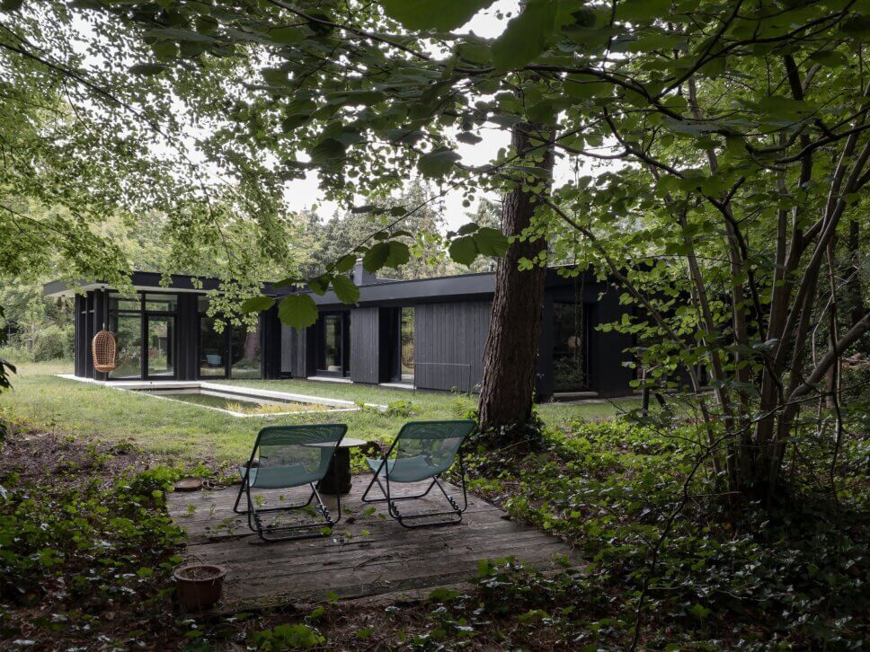 Mit schwarzem Holz verkleideter moderner Bungalow mit Pool im Garten