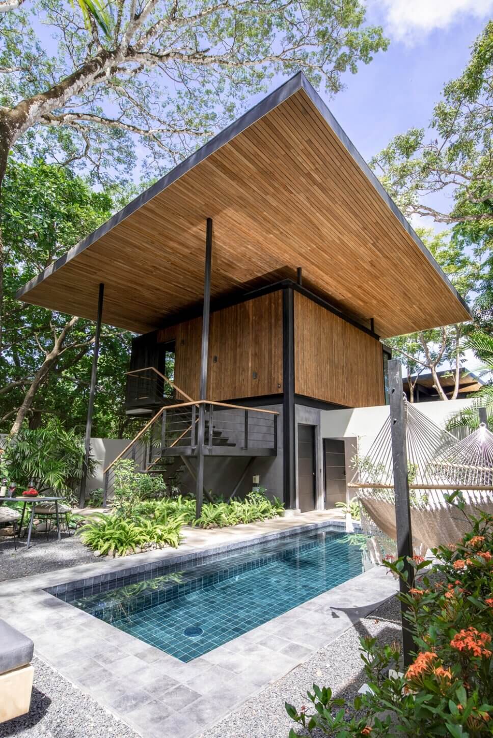 Modern eingerichtete Terrasse mit Swimmingpool in Architektur aus Holz und Glas im tropischen Regenwald