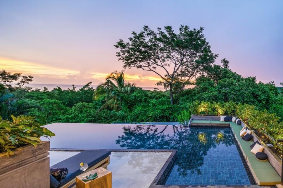 Modern eingerichtete Terrasse mit Swimmingpool in Architektur aus Holz und Glas im tropischen Regenwald
